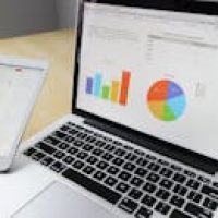 pexels-photo-265087-265087 Laptop displaying charts and graphs with tablet calendar for data analysis and planning.